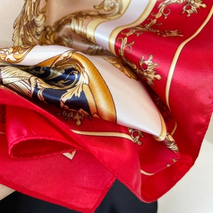 Detail of red and gold baroque satin scarf showing luxury paisley print and glossy silk texture