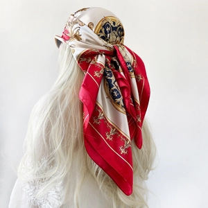 Elegant red and gold baroque print satin scarf tied as a headpiece on a model