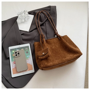 Detail of dark brown matte suede tote bag with woven knot strap and mini pouch