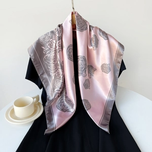 Dettaglio di una sciarpa di seta rosa con stampe di rose su un abito nero