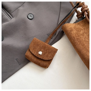 Detail of caramel suede mini pouch with silver snap button on vintage tote bag