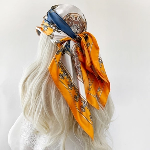 Close-up of silk-textured square scarf with paisley pattern worn as a headscarf