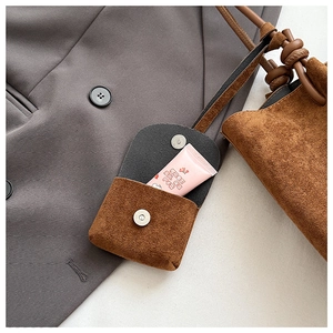 Close-up of caramel matte leather small pouch with magnetic buckle and shoulder strap
