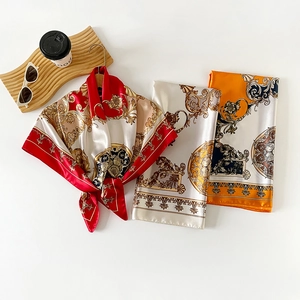 Detailed view of baroque patterned silk scarves with elegant floral ornaments on satin fabric