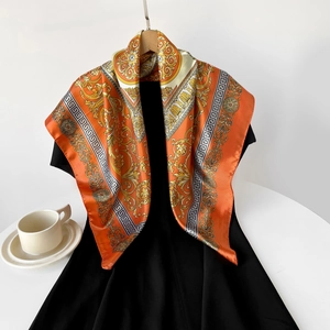 Details des orangefarbenen Satinschals mit goldenem Barockmuster und Mäanderbordüre