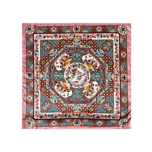 Overhead flat lay of a square satin scarf featuring vintage floral and pavilion patterns