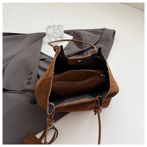 Detail view of large caramel suede tote bag featuring drawstring closure and inner pouch