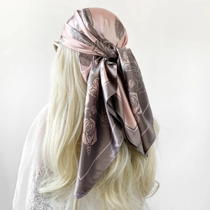 Vista dettagliata del foulard in seta satinata con motivo a rose rosa e grigie su bianco