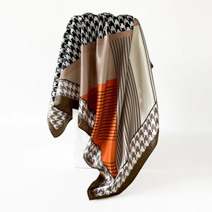 Detail of satin scarf showing houndstooth patterns and elegant drapes on a white stand