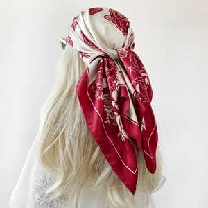 Dettaglio di un foulard in seta satinata con rose rosse indossato in stile vintage