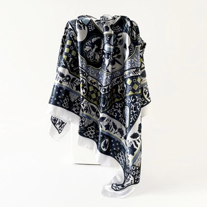 Detail of a vintage floral satin scarf with a glossy finish draped over a white stand