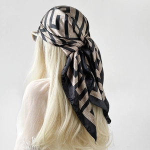 Detail view of square satin scarf with geometric pattern worn as a vintage headscarf