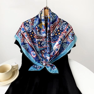 Detail view of retro floral print silk scarf styled as a wrap on a black dress