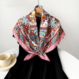 Close-up of a satin square silk scarf with vintage floral and bird prints on a dress