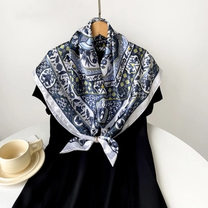 Detail view of retro blue and white silk printed square scarf on a black dress