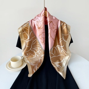 Detail of elegant satin square scarf with floral print draped over a black dress