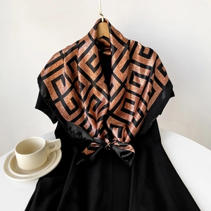 Detail of a 90cm satin square scarf with brown geometric pattern tied on a dress neck