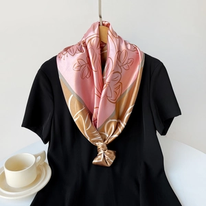 Detail of satin floral scarf showing smooth texture and elegant drape on black dress