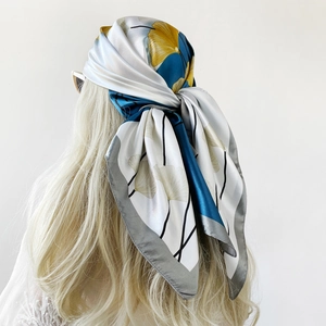 Detail of silk scarf with ginkgo leaf pattern worn as an elegant headscarf for women