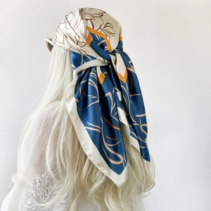 Detail of silk satin headscarf with abstract floral print in blue and orange