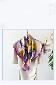 Detail of printed satin silk scarf with abstract floral patterns and elegant purple border