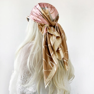 Close-up of pink and gold floral satin headscarf tied on long hair with soft drape