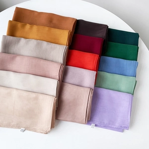 Macro detail of Turkish solid color scarves with premium fabric texture and labels