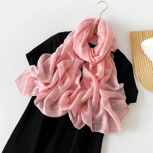 Detalle de bufanda de seda rosa con textura jacquard a cuadros en percha