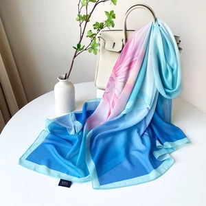 Détail d'un foulard en soie à imprimé floral drapé sur un sac à main beige élégant