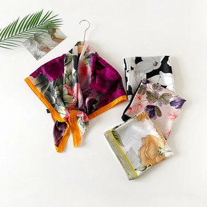 Detail of four floral print satin silk scarves with smooth glossy texture and various patterns