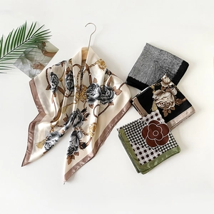 Detailed close-up of elegant satin scarves featuring floral and chain patterns on white