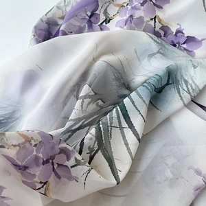Détail d'une écharpe en soie blanche élégante avec imprimé floral violet et texture douce