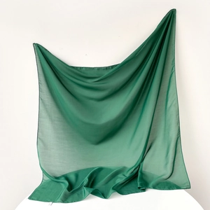 Detail of dark green lightweight solid scarf showing sheer fabric texture and edge stitching