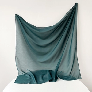Detail of teal chiffon fabric showing lightweight texture and fine rolled edge stitching