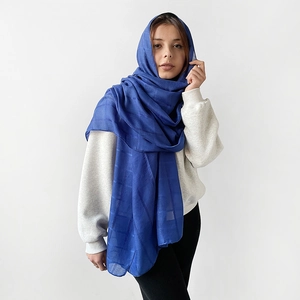 Pañuelo largo de seda azul marino con textura de cuadrícula llevado por modelo en fondo blanco