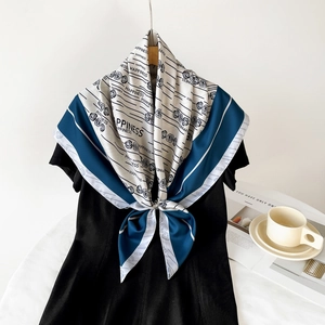Détail du foulard en soie blanche à bordure bleue avec roses noires et motif Happiness