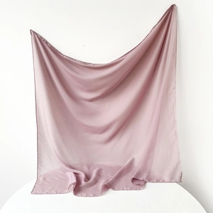 Detail of soft mauve chiffon hijab showing the lightweight fabric texture and draped hem