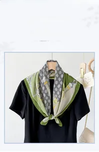 Detail of green satin scarf featuring golden chain and equestrian paisley print pattern