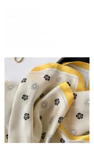 Close-up of smooth satin square scarf showing silk texture and camellia flower patterns