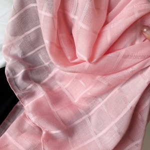 Primer plano de bufanda rosa a cuadros con textura de seda suave y tejido transparente