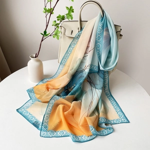 Détail d'une écharpe en soie à imprimé floral avec dégradé élégant et bordures à volutes