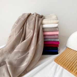 Primer plano de bufandas ligeras con textura de rejilla en varios colores y caída natural