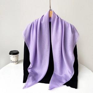 Detail shot of light purple chiffon scarf material draped on a hanger and sweater