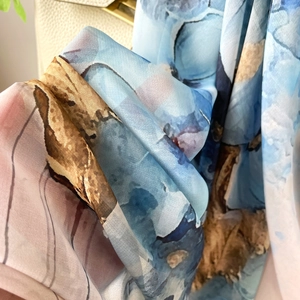 Détail d'un foulard en soie aux imprimés floraux aquarelle et bords roulés fins