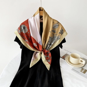 Elegant 90cm floral silk scarf in red and ginger yellow draped on a black dress