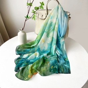 Détail de l'écharpe fleurie en satin drapée sur un sac à main crème avec lumière douce