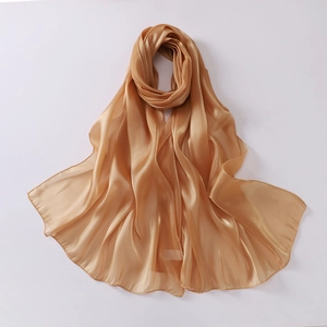 Detail of elegant champagne gold organza scarf with glossy satin texture and fine edges