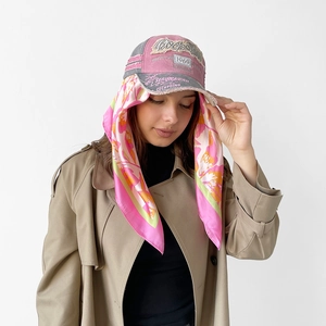 Fashionable gray and pink baseball cap with floral silk scarf detail worn by a model