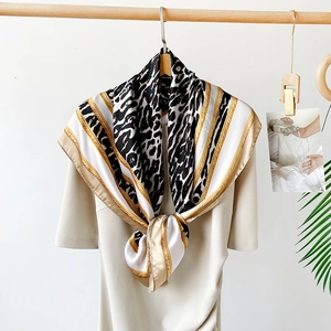 Detail of satin scarf featuring black and white leopard print and golden chain pattern