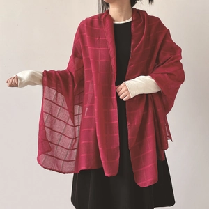 Detalle de un pañuelo rojo de rejilla ligero sobre un vestido negro estilo chal